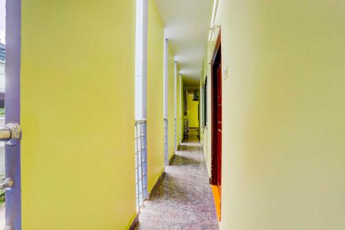 an empty hallway with yellow walls and a red door at Hotel O Tirupati Railway Junction Y Stay Home Stay in Tirupati