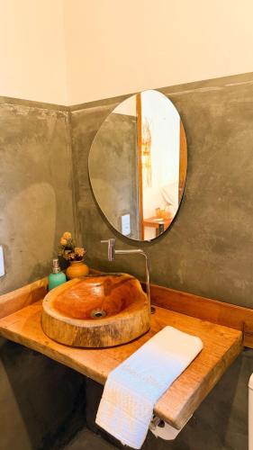 a bathroom with a wooden sink and a mirror at Bossa Atins in Atins