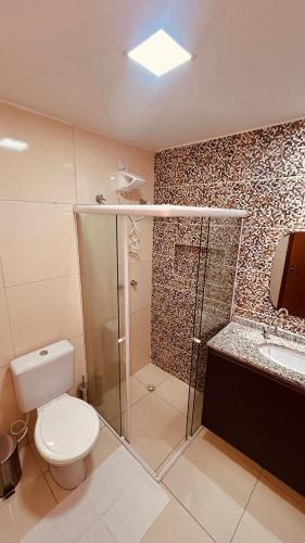 a bathroom with a shower and a toilet and a sink at Flat Residencial dos Anjos in Maceió