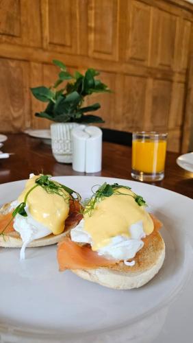 Dos sándwiches de huevo en un plato blanco sobre una mesa. en Lakeview Manor, en Dunkeswell