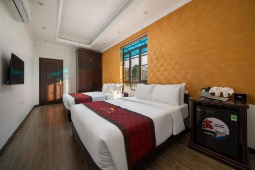a hotel room with two beds and a window at Tam Coc Babylon Hotel in Ninh Binh