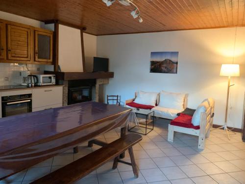 eine Küche mit Tisch und Stühlen in einem Zimmer in der Unterkunft Gîte À La Ferme Au Puy Mary in Mandailles