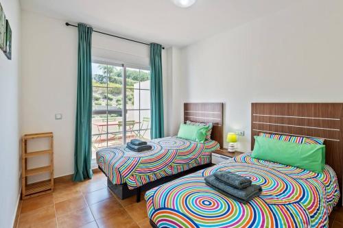 a bedroom with two beds and a balcony at Casa del Color - Alcaidesa in San Roque