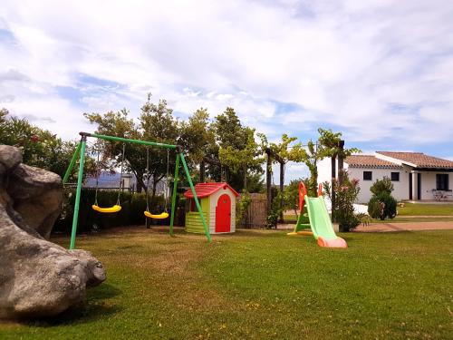 a playground with slides and swings in a yard at Sa Prata Hotel & Resort in Budoni