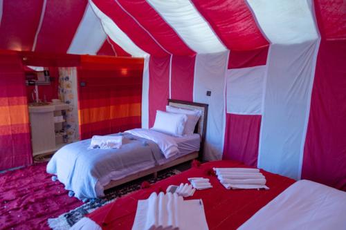 a bedroom with a tent with two beds in it at Erg Chebbi Dunes Desert Camp in Merzouga
