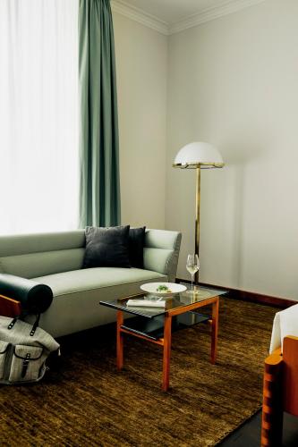 a living room with a couch and a table at Parkhotel Laurin in Bolzano