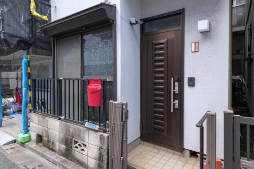 a red shirt is hanging on a fence next to a door at Omo-Yado 20 minutes by car from Haneda Entire house in Tokyo