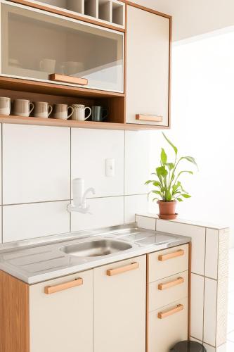 a kitchen with white cabinets and a sink at Apartamento COP 30 in Ananindeua