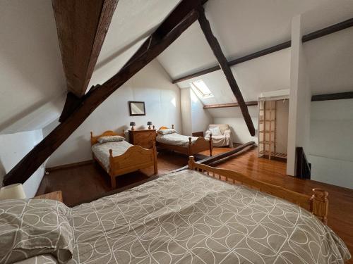 a attic room with a large bed and a bedroom at Les Grands Gîtes de Janaillat in Janaillat