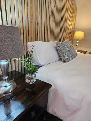 a bedroom with a bed and a table with a lamp at Kamberg Cottages in Mooiriver