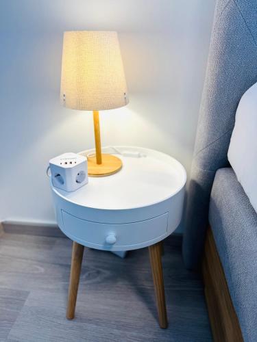 a table with a lamp on it next to a bed at Design City Apartment, Dachterrasse, Top Lage in Schwetzingen