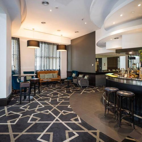 a hotel lobby with a bar and stools at One bedroom Hospitality Suite in Sydney