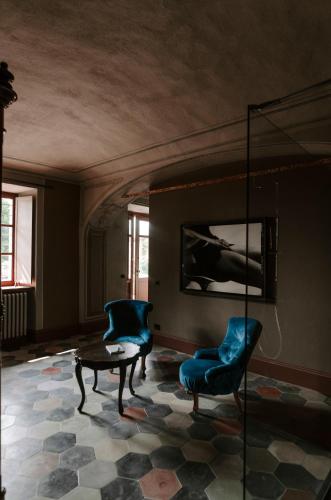 a living room with two blue chairs and a table at Vigne di Fagnano 1709 Eco Relais in Santo Stefano Belbo