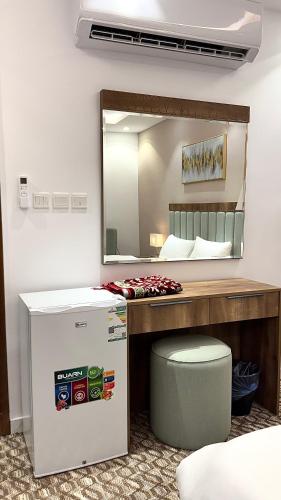 a room with a bed and a mirror and a cooler at Roaa Al-Jamwaut in Medina