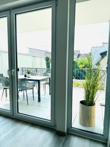 an open glass door with a patio with a table at Design City Apartment, Dachterrasse, Top Lage in Schwetzingen