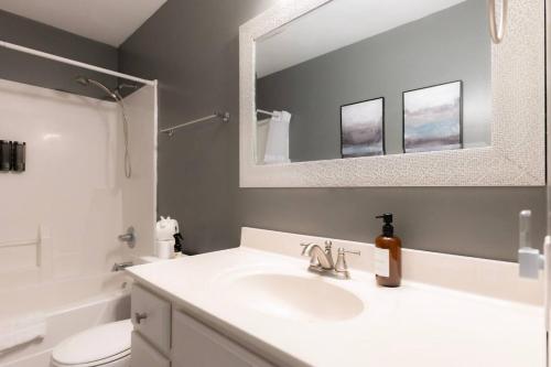 a bathroom with a white sink and a mirror at The Family Haven - 3BD 3BA Home in East Peoria in West Peoria