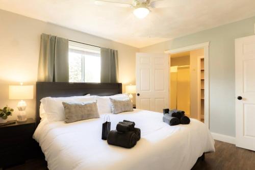 a bedroom with a large white bed with two bags on it at The Family Haven - 3BD 3BA Home in East Peoria in West Peoria