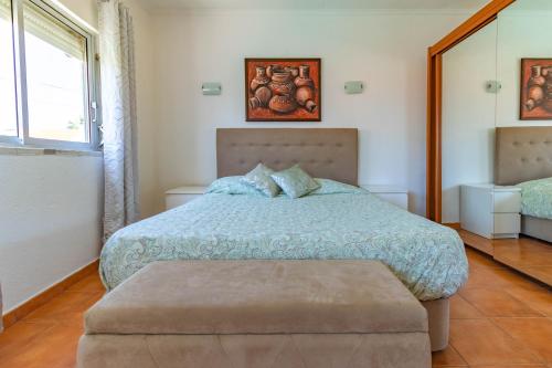 a bedroom with a bed with a blue comforter at Caparica Beach Stay in Costa da Caparica