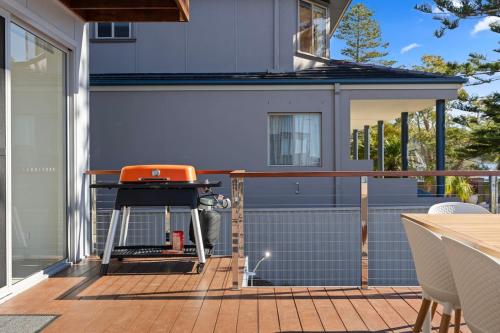 a patio with a grill on a deck at New Waterfront Escape with Private Jetty in Woy Woy