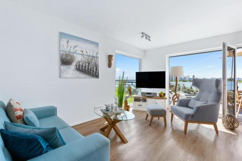 a living room with a blue couch and a tv at Pamir in Kappeln
