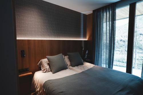 a bedroom with a bed and a large window at Isard Homes by Select Rentals in El Tarter