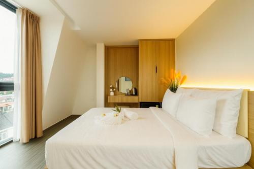 a large white bed in a room with a window at Amory Dalat Hotel in Khu Chi Lăng
