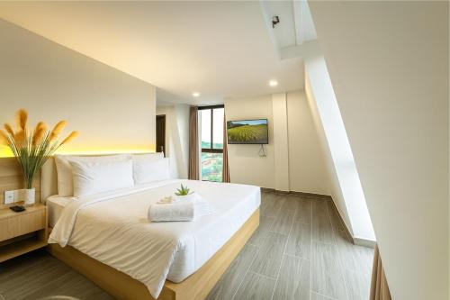 a bedroom with a large white bed and a window at Amory Dalat Hotel in Khu Chi Lăng