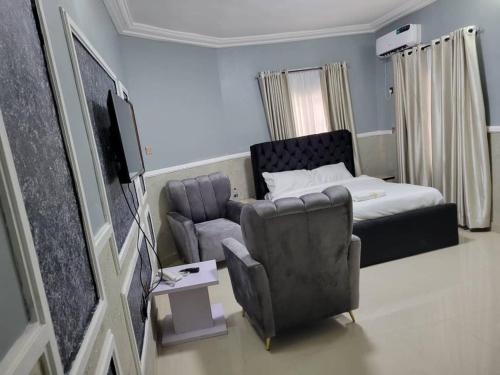 a room with a bed and a couch and a chair at International Royal Hotel in Owerri