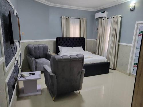 a living room with a bed and a couch and a chair at International Royal Hotel in Owerri