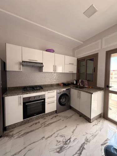 a kitchen with white cabinets and a dishwasher at Residence Plaza de Toros in Tangier