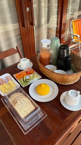 een houten tafel met daarop eten en een dienblad met eten bij Bossa Atins in Atins