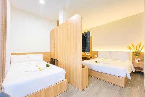 two beds in a hotel room with white sheets at Amory Dalat Hotel in Khu Chi Lăng