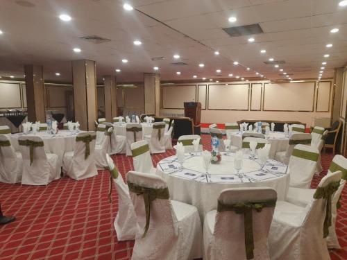 a room filled with tables and chairs with white linens at Islamabad Hotel in Islamabad
