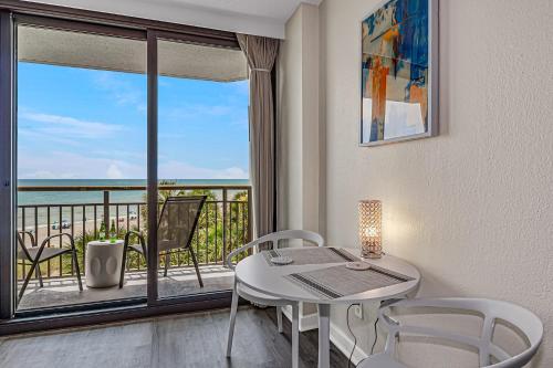 a dining room with a table and chairs and a balcony at Casa Palmera By Casanita - Small-Dog Friendly Suite in Myrtle Beach