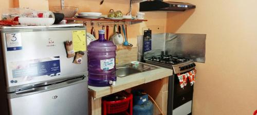 a kitchen with a bottle on the counter next to a sink at Casa El Guayacan in Baños