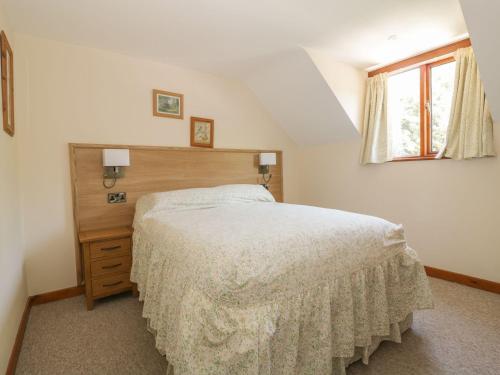 une chambre avec un grand lit et une fenêtre dans l'établissement Heron Cottage, à Norwich