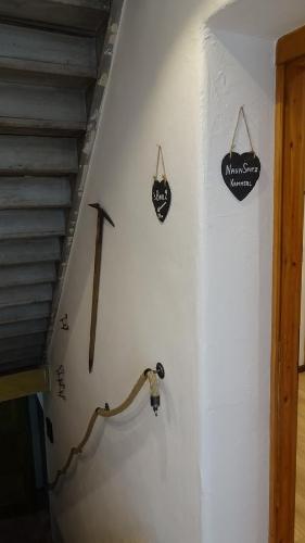 a white wall with two signs on a stair case at Hoamatl in Ebbs
