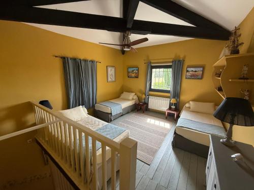 a small room with two beds and a staircase at Moulin AURELIA in La Barben