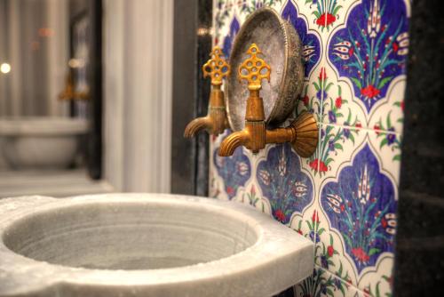 a bathroom sink with a faucet on a wall at Marti Beach Hotel in Kuşadası