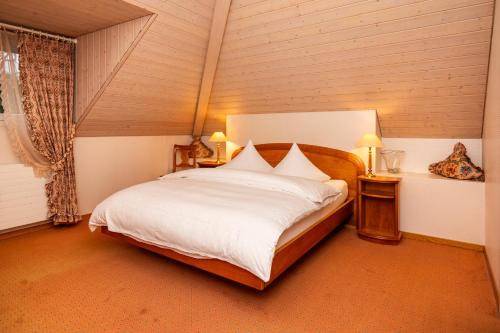 a bedroom with a large bed with white sheets at Romantik Hotel & Restaurant Sternen in Kriegstetten