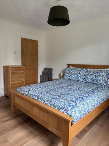 a bedroom with a bed with a blue comforter at Highland Nook in Fort William