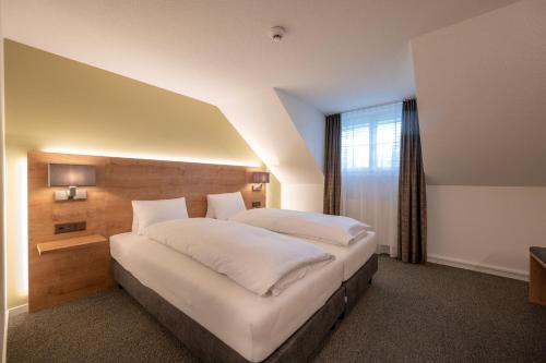 a hotel room with two beds and a window at Romantik Hotel & Restaurant Sternen in Kriegstetten