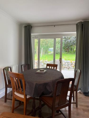 a dining room with a table and chairs and a window at Highland Nook in Fort William