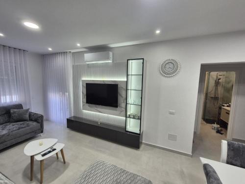 a living room with a couch and a tv at New Comfort Apartment in Golem