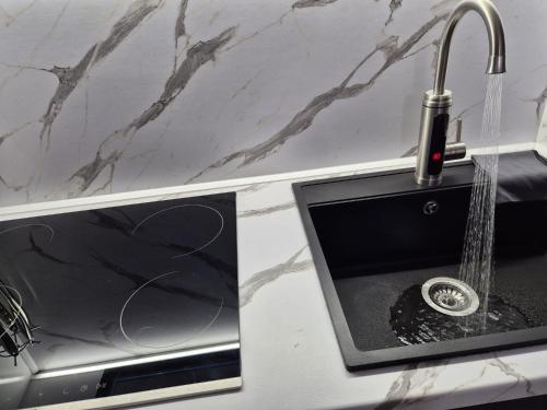 a kitchen with a sink with a faucet at New Comfort Apartment in Golem