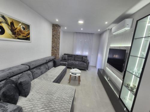 a living room with a couch and a tv at New Comfort Apartment in Golem
