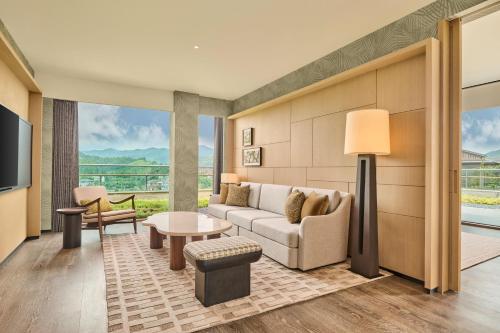 a living room with a couch and a table at Shu Hua Hotel Tianmu Mountain, Curio Collection By Hilton in Hangzhou