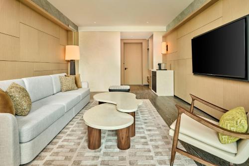 a living room with a couch and a flat screen tv at Shu Hua Hotel Tianmu Mountain, Curio Collection By Hilton in Hangzhou