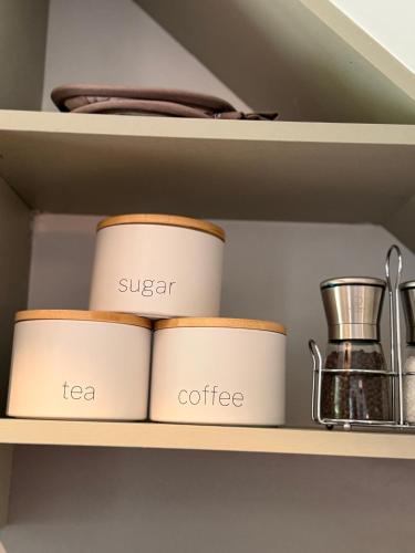 a shelf with three cups and a tea and coffee at Highland Nook in Fort William