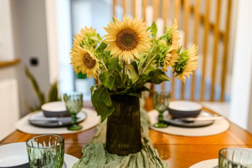 a vase filled with sunflowers sitting on a table at Villa Caza in Chişinău